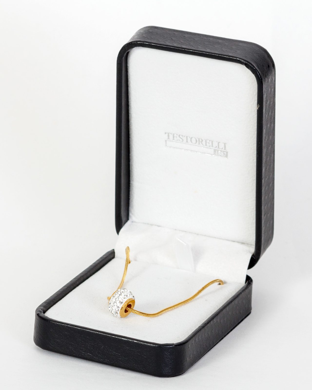 Collar dorado con dije de cristales en su estuche abierto, sobre fondo blanco